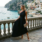Black one-shoulder pleated midi dress with gathered skirt and fitted waist
