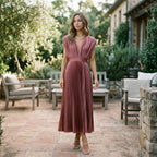 Antique pink pleated V-neck dress with short sleeves and fitted waist, flowing mid-calf hem