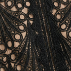 Close-up of black lace fabric with circular and fan-shaped embroidery