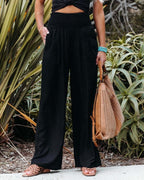 Black high-waisted linen wide-leg trousers with gathered smocked waistband
