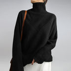 Women’s cashmere turtleneck sweater in black with ribbed collar and diamond knit panel.