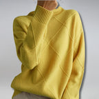 Women’s cashmere turtleneck sweater in yellow with ribbed collar and diamond knit design.