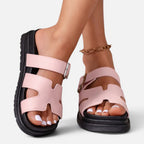 Pink platform sandals with adjustable ankle straps and open toe cutouts