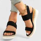 Black two-strap platform sandals with open toe and jute midsole, ankle chain detail