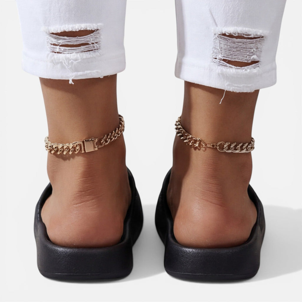 Women’s slide sandals in black with open toe and gold chain ankle bracelet