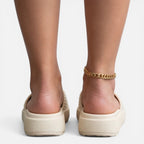 Women’s slide sandals with ribbed beige footbed and woven gold ankle chain