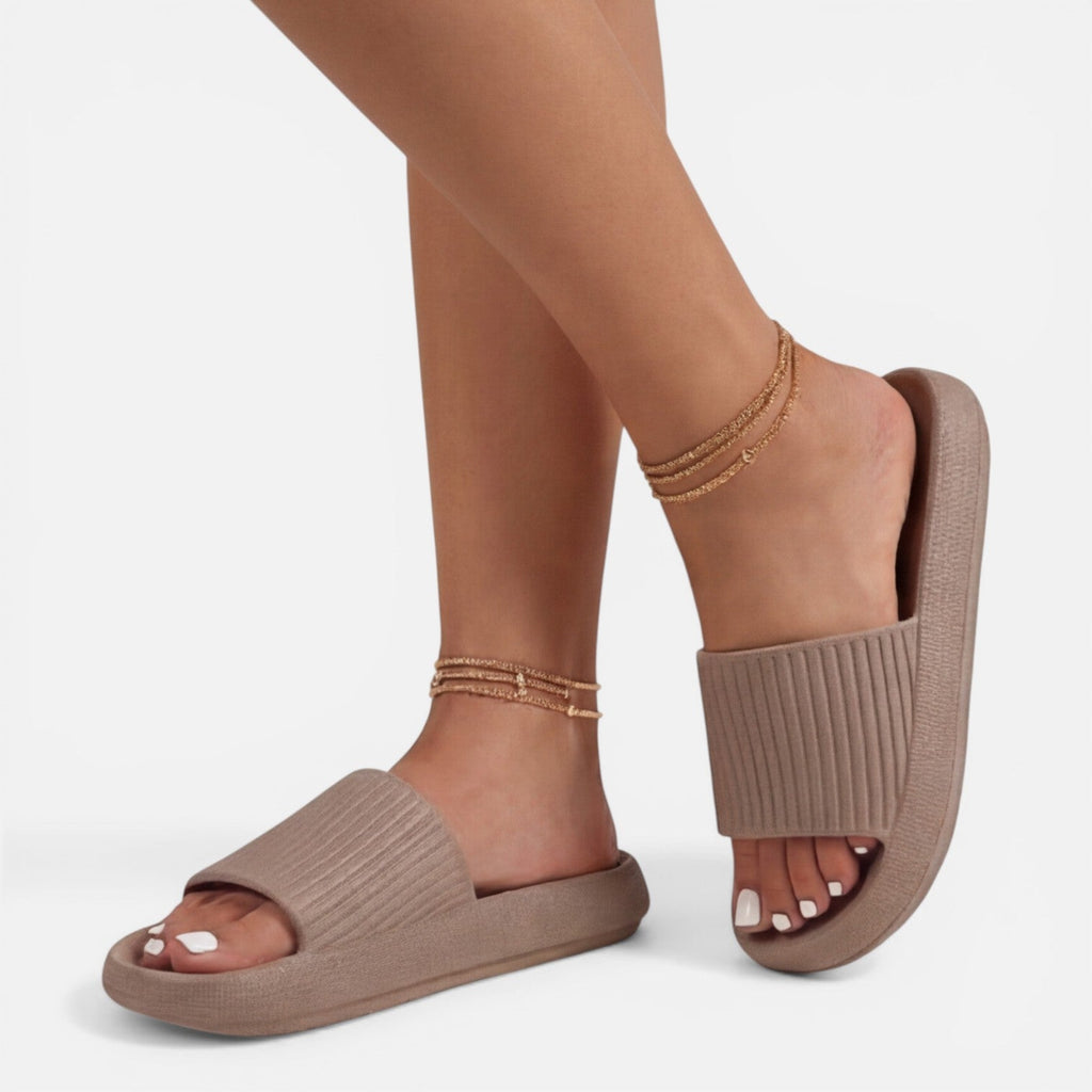 Beige women’s slide sandals with cushioned footbed and ribbed strap, open toe