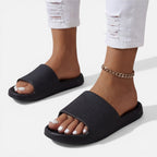 Women’s slide sandals in black with open toe and gold chain ankle strap