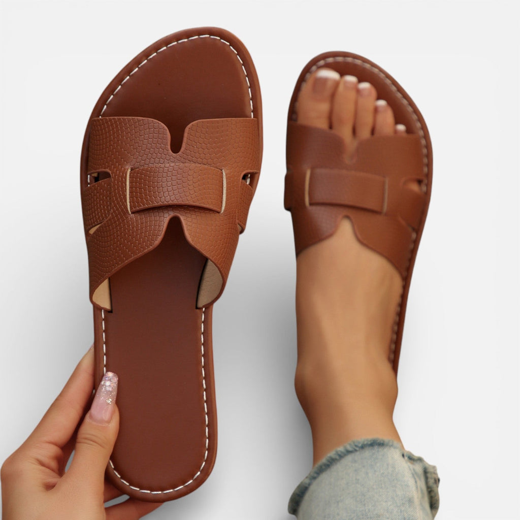 Women’s leather slide sandals, open toe, wide strap with stitched detailing, cushioned footbed.