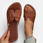 Women’s leather slide sandals, open toe, wide strap with stitched detailing, cushioned footbed.