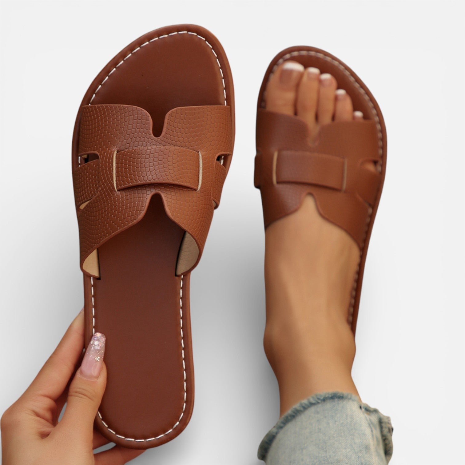 Women’s leather slide sandals, open toe, wide strap with stitched detailing, cushioned footbed.