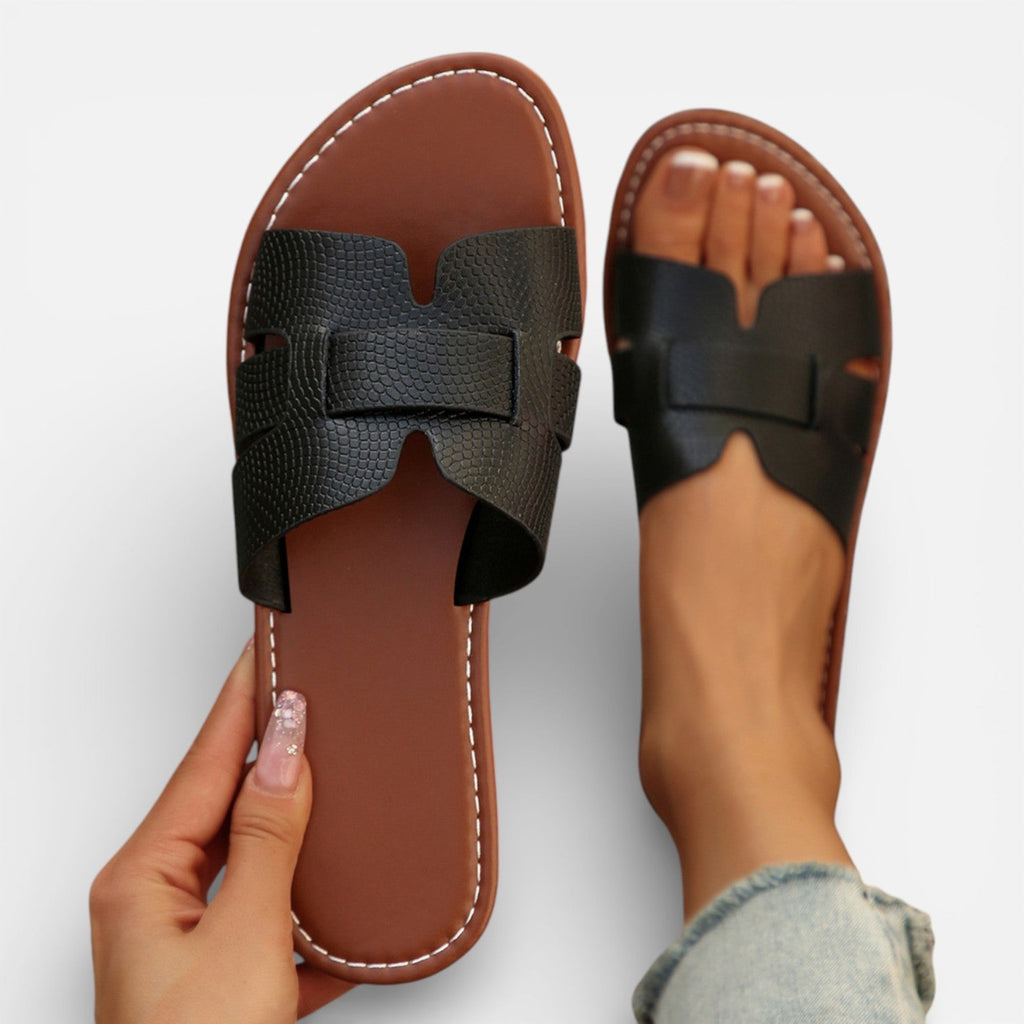 Women’s leather slide sandals, open toe, wide dark strap with stitched detailing, cushioned footbed.