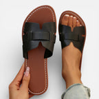 Women’s leather slide sandals, open toe, wide dark strap with stitched detailing, cushioned footbed.
