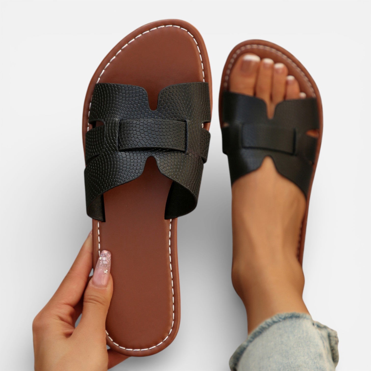 Women’s leather slide sandals, open toe, wide dark strap with stitched detailing, cushioned footbed.