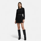 Black knee-high suede boots with rectangular buckle strap and low heel