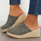 Grey closed-toe espadrille wedge mules with slip-on fit and braided jute platform.