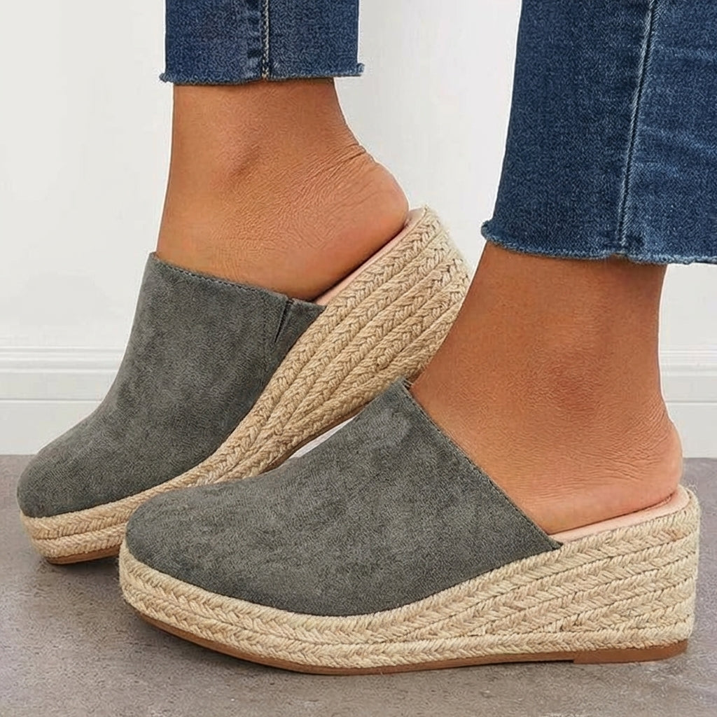 Grey closed-toe espadrille wedge mules with slip-on fit and braided jute platform.
