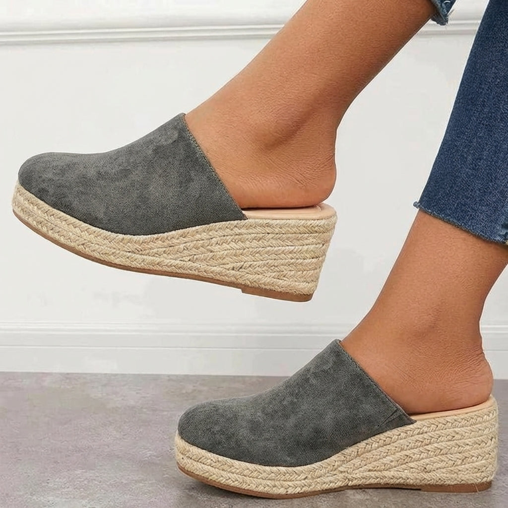 Grey closed-toe espadrille wedge mules with slip-on design and braided jute platform.