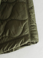 Olive green quilted bodywarmer hem with elastic cuff and side seam stitching