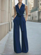 Dark blue sleeveless wide-leg jumpsuit with lapel collar, button front, waist tie belt