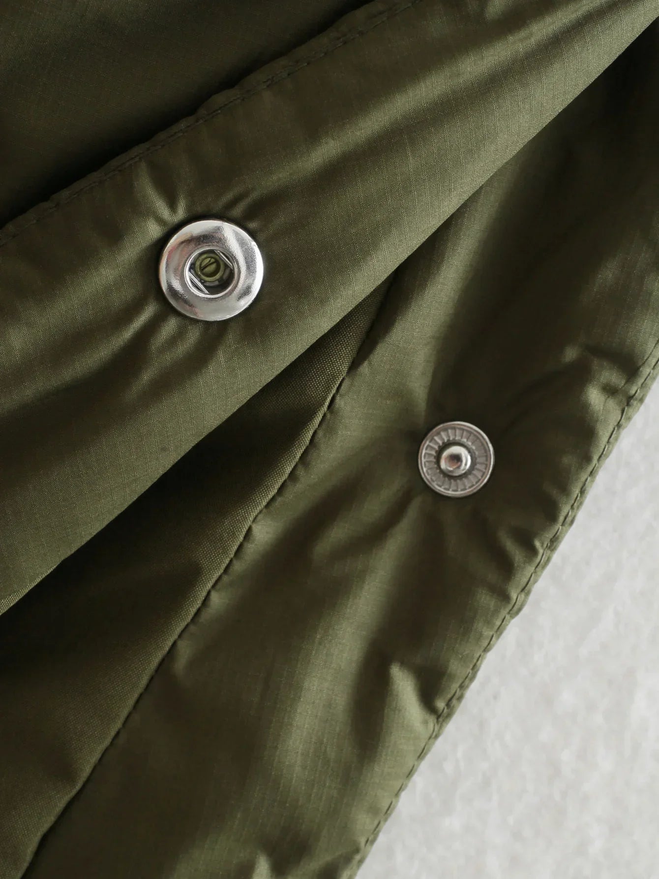 Olive jacket placket with metal snap buttons