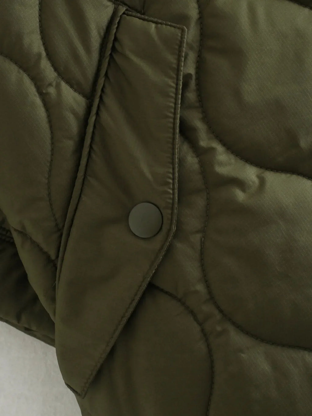 Olive green bodywarmer with angled flap pocket and round snap closure