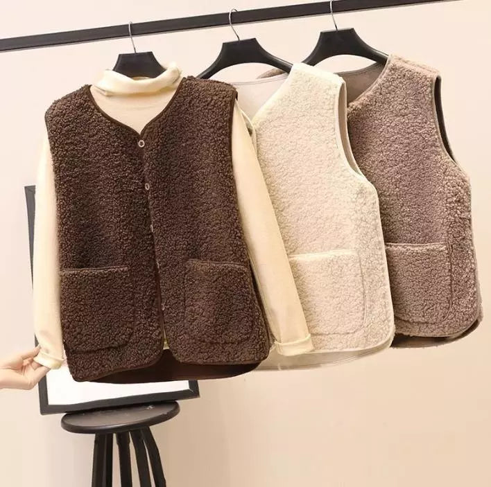 Sherpa fleece vests on hangers in dark brown, cream, and tan