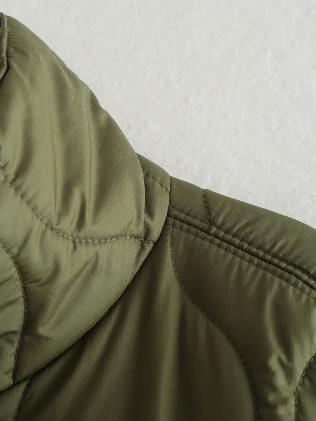 Olive quilted short-sleeve shoulder seam with stitched panel detail