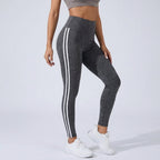 High-waisted dark gray workout leggings with three white side stripe lines.