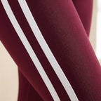Burgundy leggings detail with two white side stripe bands and textured fabric.