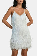 White sequin mini party dress with feather fringe hem and spaghetti straps.