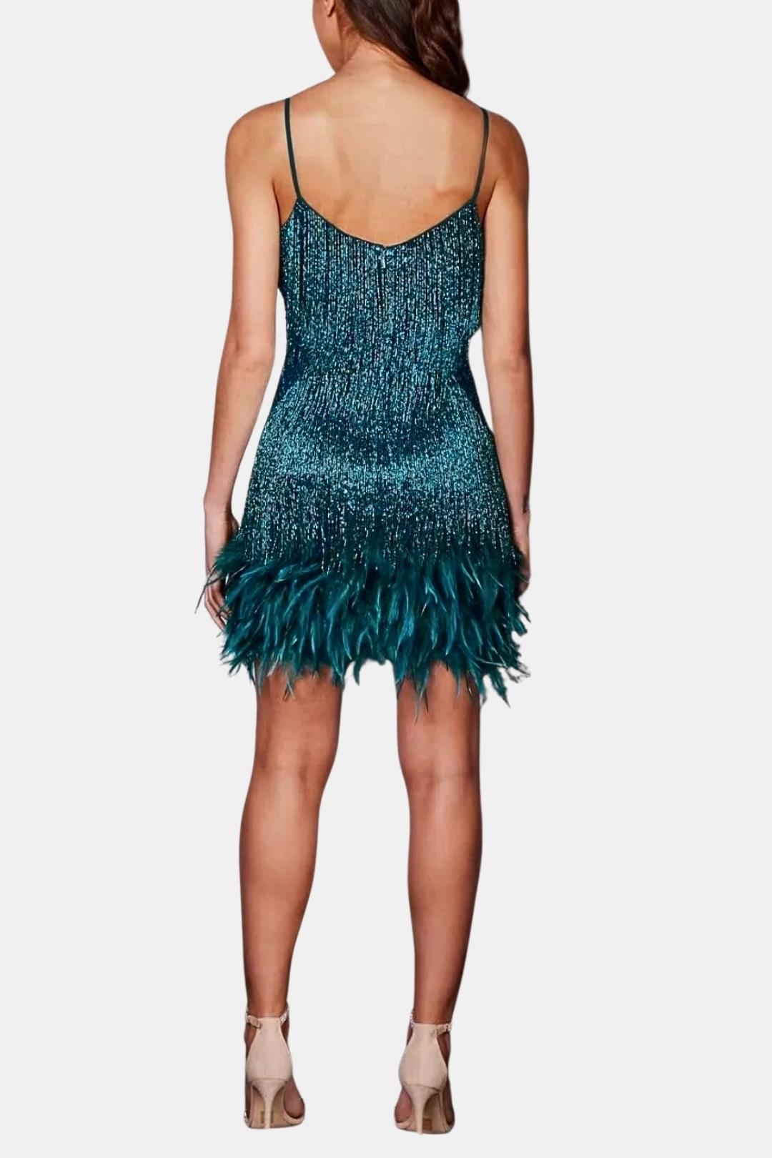 Back view of teal-blue sequin mini dress with feather fringe hem and thin straps.