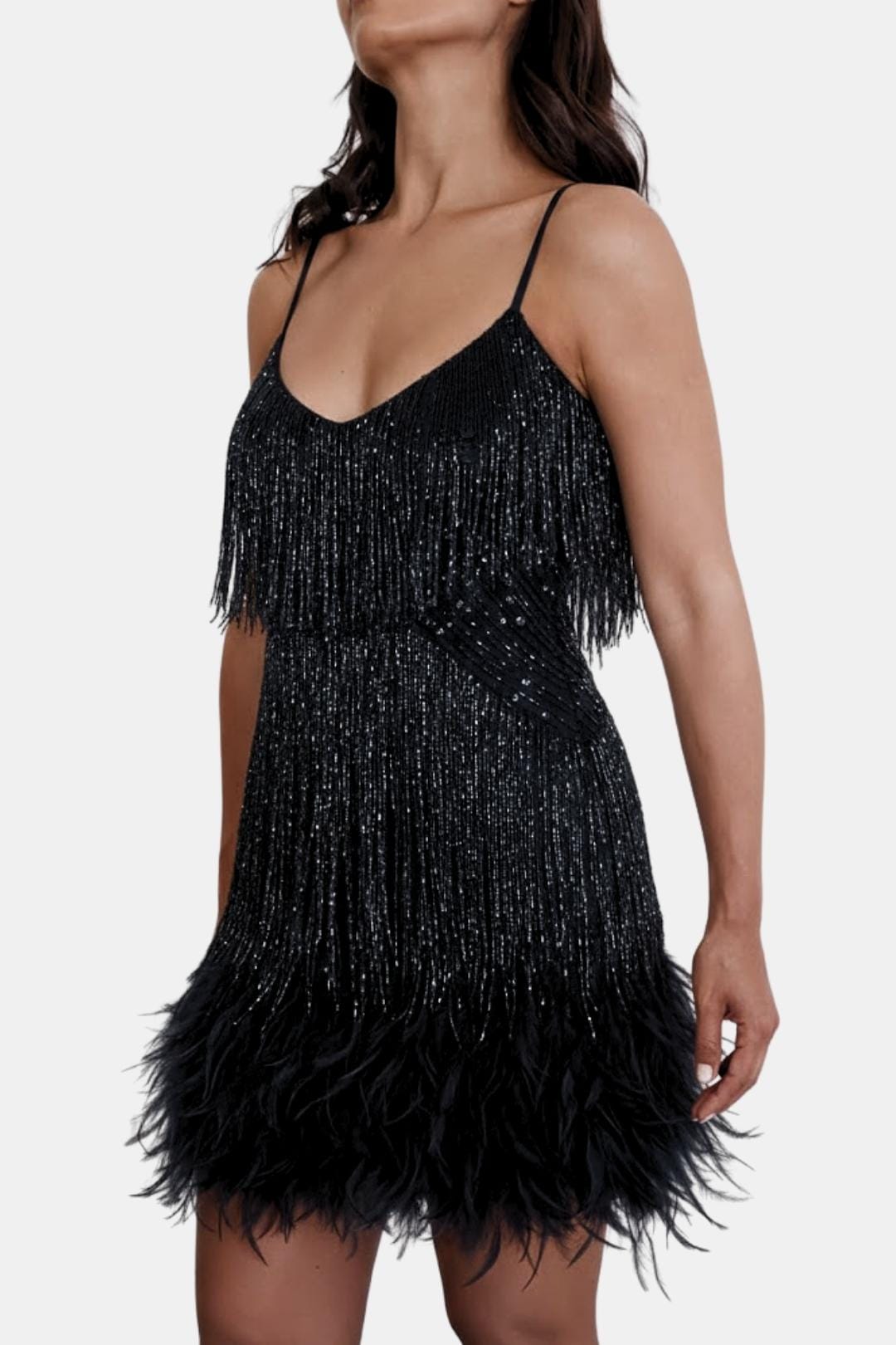 Black sequin mini party dress with feather fringe hem and thin spaghetti straps.