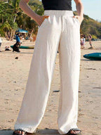 White high-waisted loose wide-leg pants shown from front with gathered elastic waist