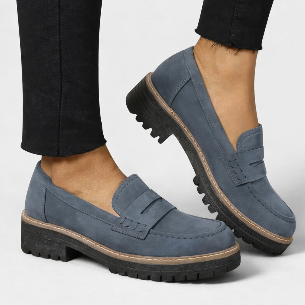Blue slip-on loafers with round toe, strap detail, and contrast edge sole