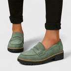 Green slip-on loafers with round toe, strap detail, and rugged tread sole