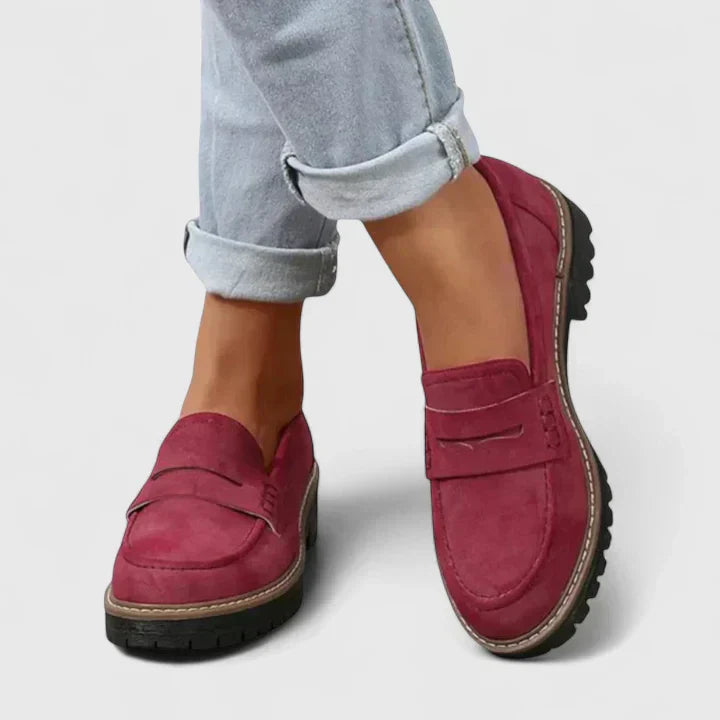Red slip-on loafers with round toe and strap detail on a chunky sole