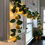yellow fruit and green leaf fairy garland with warm string lights on window frame