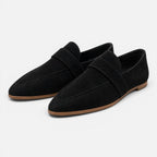 Women's black suede pointed-toe loafers, slip-on style with strap detail.