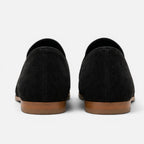 Women's black suede loafers, back view with low sole and rounded collar opening.