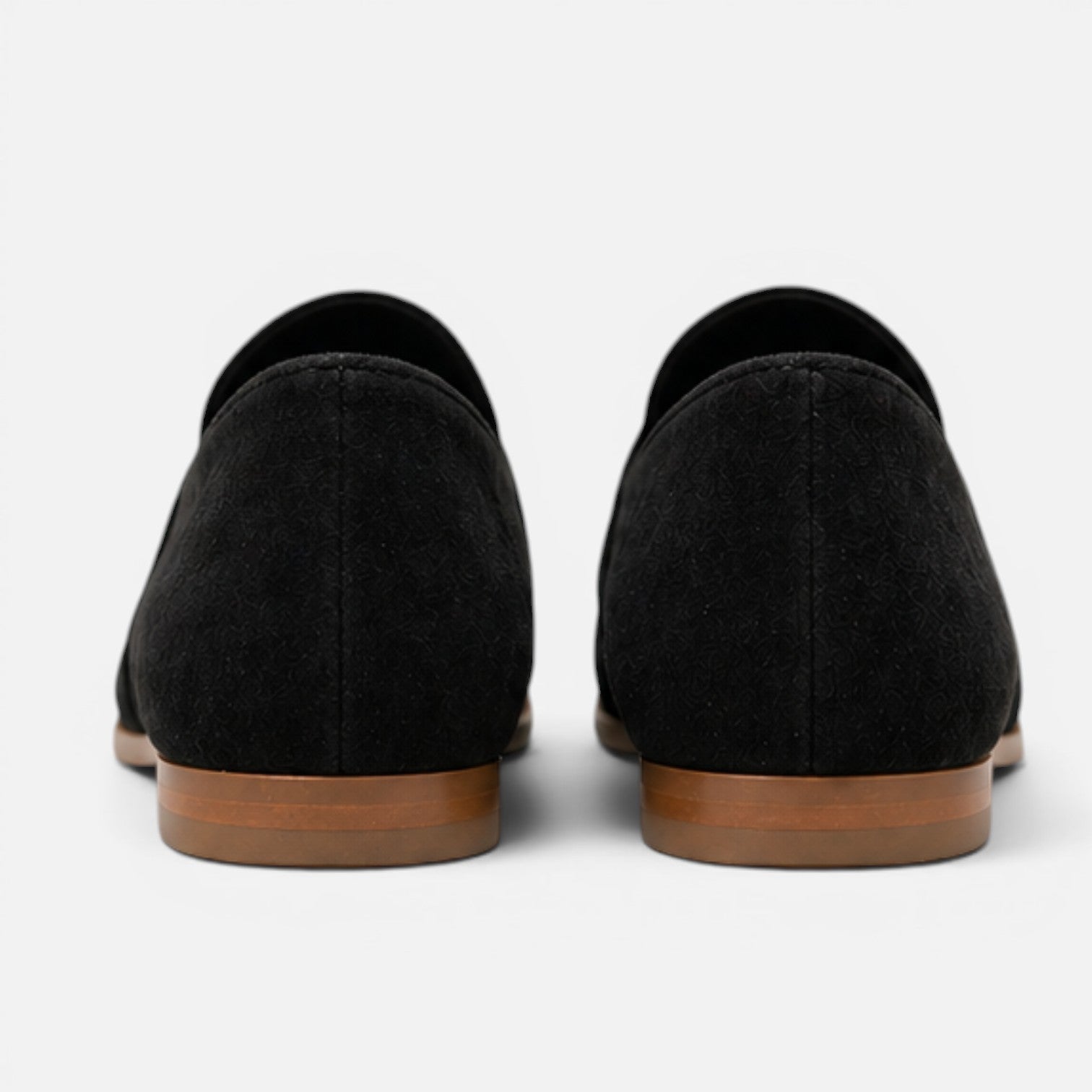 Women's black suede loafers, back view with low sole and rounded collar opening.