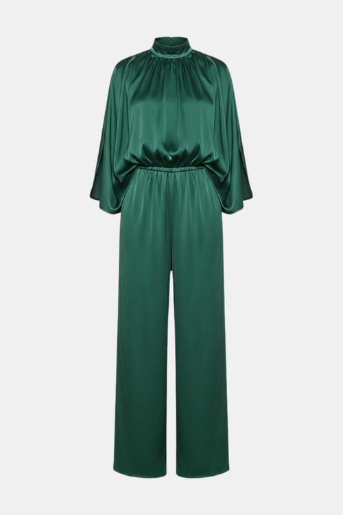 Green cape-sleeve jumpsuit with high neck and cinched waist, wide-leg pants.