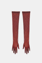 Sheer mesh elbow-length gloves in rust red with patterned stretch and fringed fingertips.