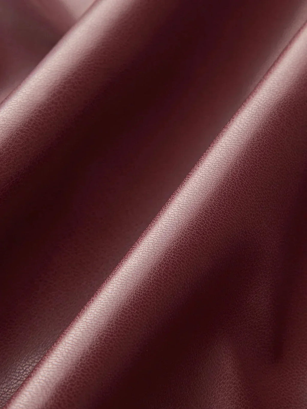 Burgundy faux leather mock-neck top fabric with subtle sheen and textured finish