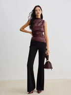 Burgundy sleeveless faux leather mock-neck top with high neckline and fitted drape front