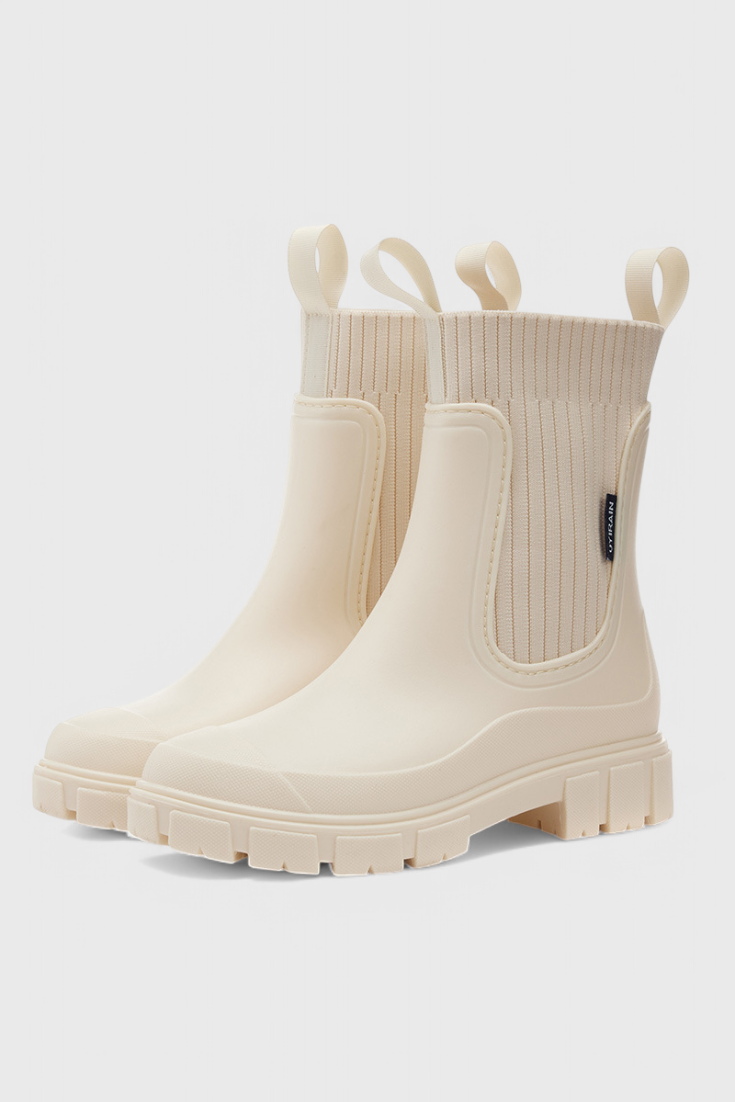 Beige slip-on ankle boots with ribbed elastic shaft and side gore pull-on panel.