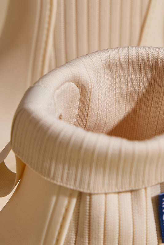 Close-up of beige slip-on ankle boot elastic gore and stitched upper detail