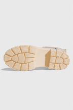 Beige slip-on ankle boots outsole, chunky tread sole with elastic side tabs.