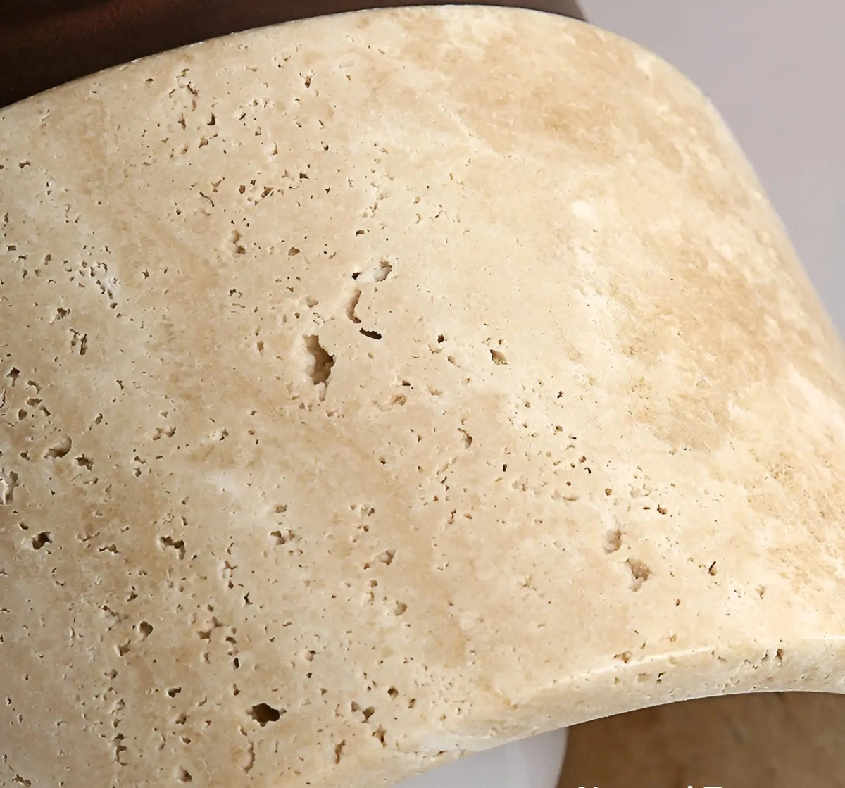Close-up of textured travertine stone cylinder shade for flush mount ceiling lamp.