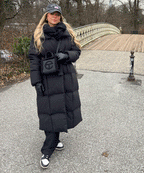 Women's long black puffer coat with hood, belted waist and front pockets